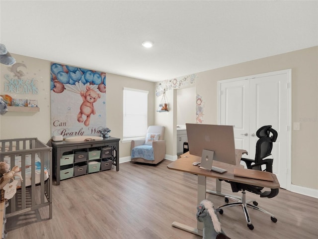 office area featuring light wood-style flooring and baseboards