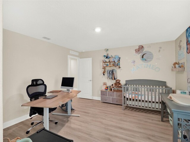 bedroom with light wood-type flooring, baseboards, and visible vents