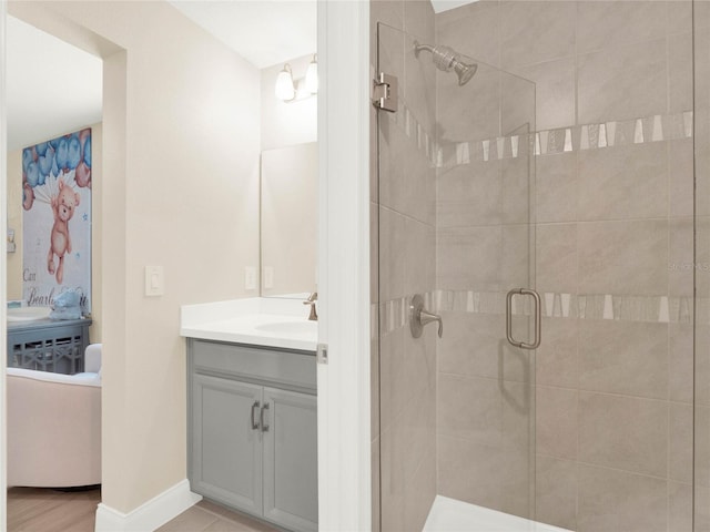 bathroom featuring baseboards, a shower stall, and vanity