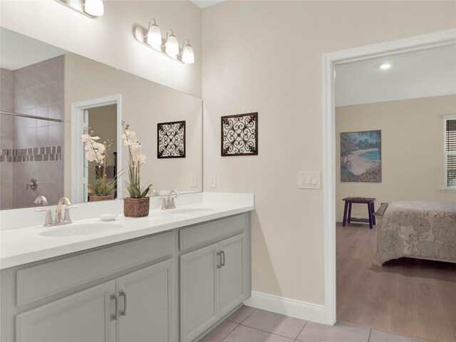 ensuite bathroom featuring ensuite bathroom, double vanity, a sink, and tile patterned floors