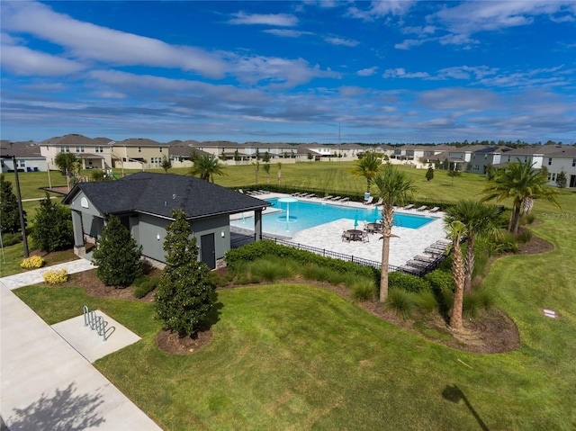 community pool featuring a residential view, a patio area, and a lawn