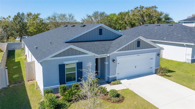 ranch-style home featuring an attached garage, driveway, a front yard, and roof with shingles