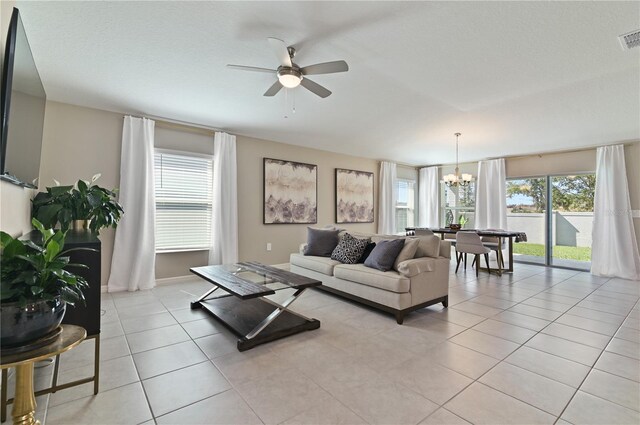 1546 Park Leah Cir, Apopka, FL 32712 - living room featuring ceiling fan with notable chandelier, visible vents, a textured ceiling, and light tile patterned flooring