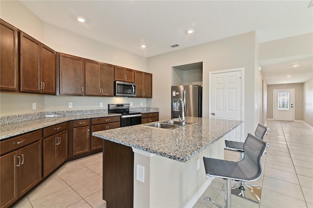 1546 Park Leah Cir, Apopka, FL 32712 - kitchen with appliances with stainless steel finishes, a sink, a center island with sink, and light stone countertops