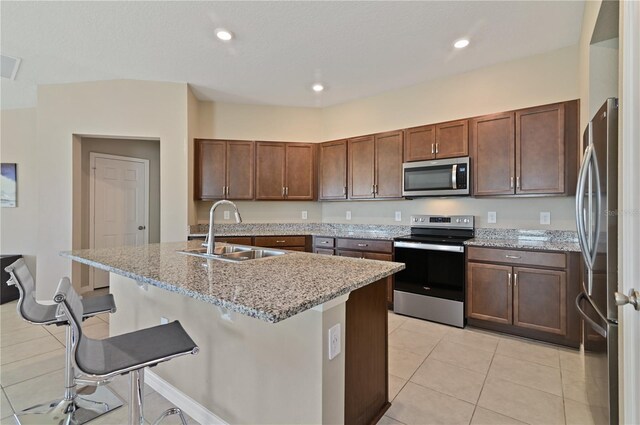 1546 Park Leah Cir, Apopka, FL 32712 - kitchen with appliances with stainless steel finishes, a kitchen island with sink, a sink, and light stone countertops