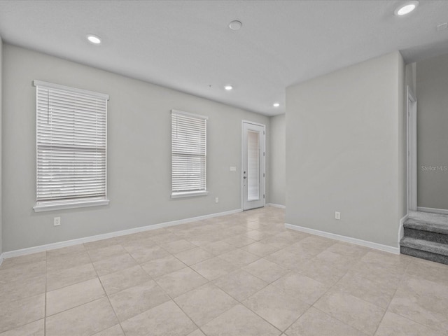 empty room with recessed lighting and baseboards