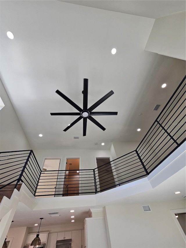 stairway featuring visible vents, ceiling fan, a towering ceiling, and recessed lighting