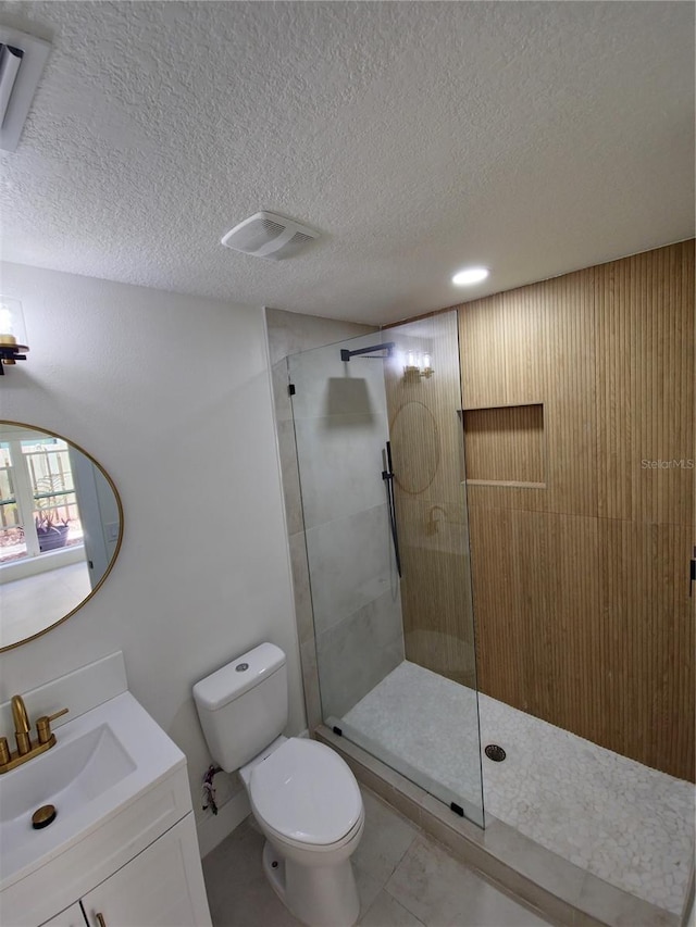 bathroom featuring visible vents, walk in shower, a textured ceiling, and vanity