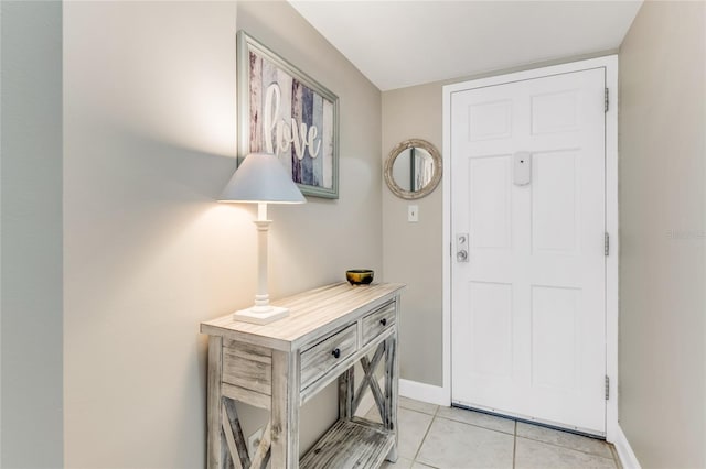 foyer entrance featuring light tile patterned floors and baseboards