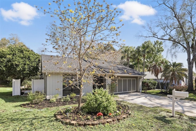 view of front of property featuring driveway, a garage, and a front yard