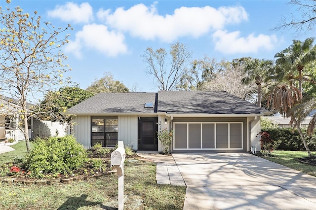 view of front of property with a shingled roof, driveway, and an attached garage