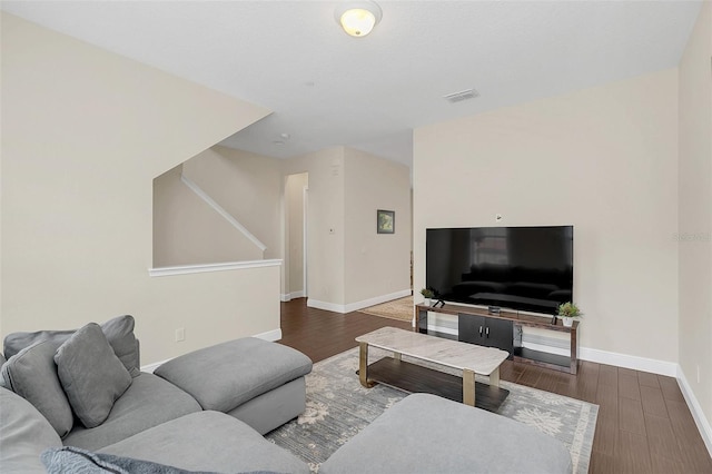 living area with baseboards, visible vents, and dark wood-type flooring