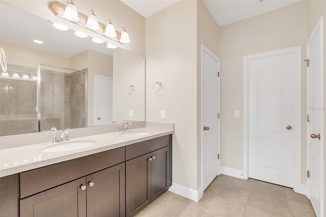 bathroom with a sink, a shower stall, baseboards, and double vanity