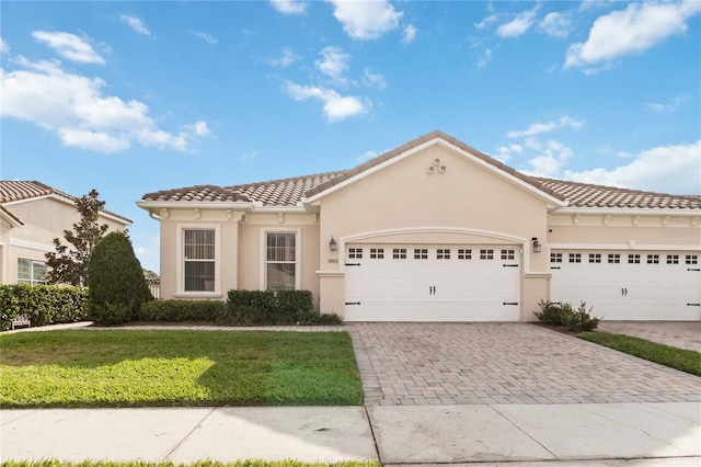 mediterranean / spanish-style home with a front lawn and a garage