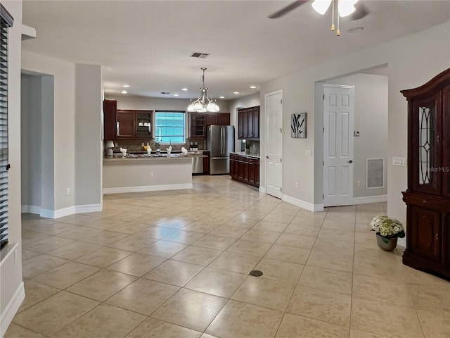 interior space with ceiling fan with notable chandelier, light tile patterned flooring, and hanging light fixtures