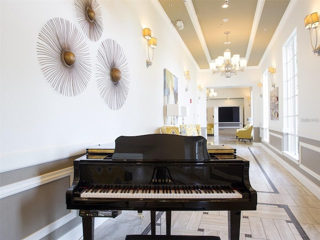 living area with a tray ceiling, light tile patterned floors, crown molding, and an inviting chandelier