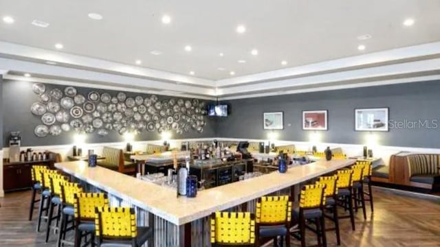 interior space with a tray ceiling and dark parquet flooring