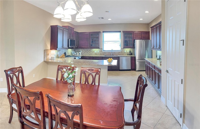 tiled dining area with a notable chandelier and sink