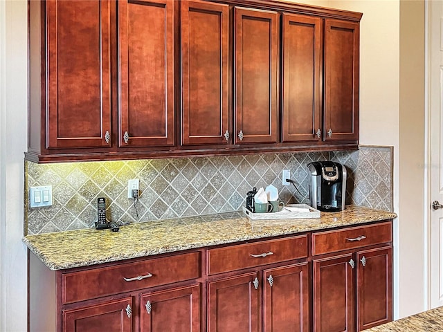 kitchen featuring tasteful backsplash and light stone counters