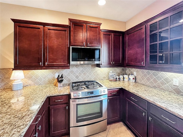 kitchen with backsplash, stainless steel appliances, and light stone counters