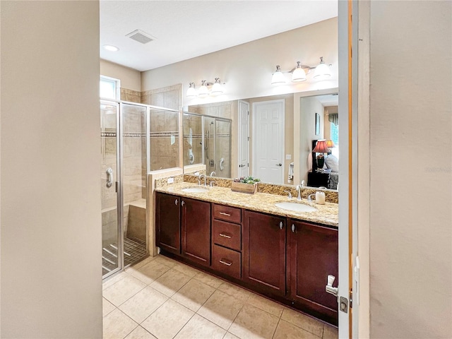 bathroom featuring tile patterned floors, a shower with shower door, and vanity