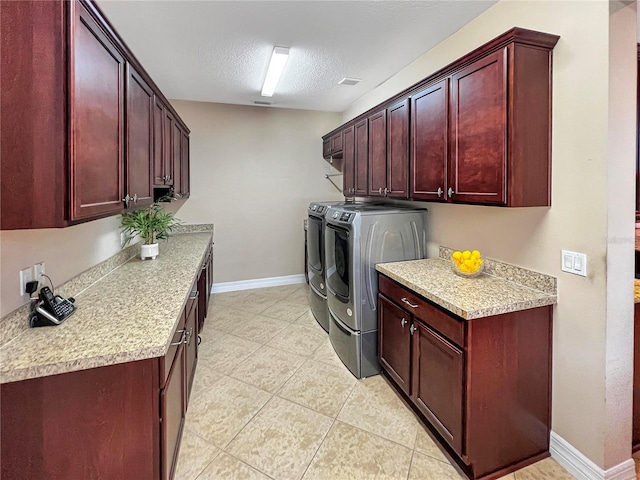 laundry room featuring washer and dryer, cabinets, a textured ceiling, and light tile patterned floors