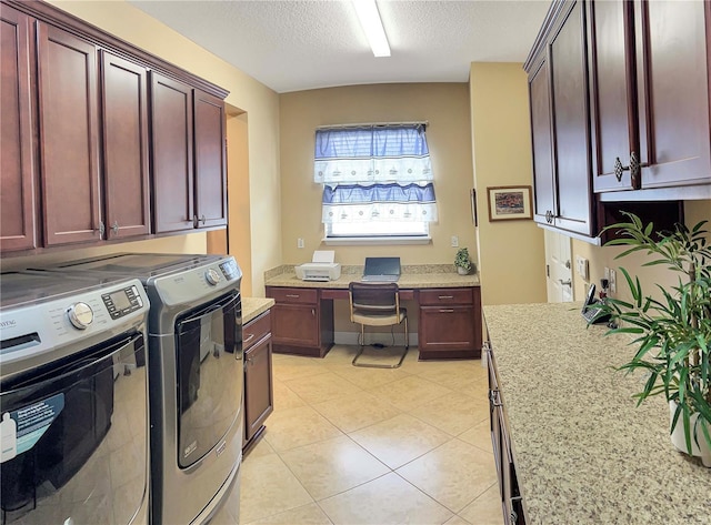 washroom featuring a textured ceiling, cabinets, washing machine and clothes dryer, and light tile patterned floors