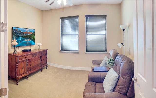 living area with light colored carpet and ceiling fan