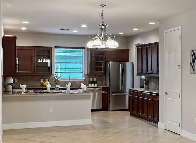 172 Balmy Coast Rd, Groveland, FL 34736 - kitchen featuring freestanding refrigerator, decorative backsplash, dark brown cabinets, glass insert cabinets, and decorative light fixtures