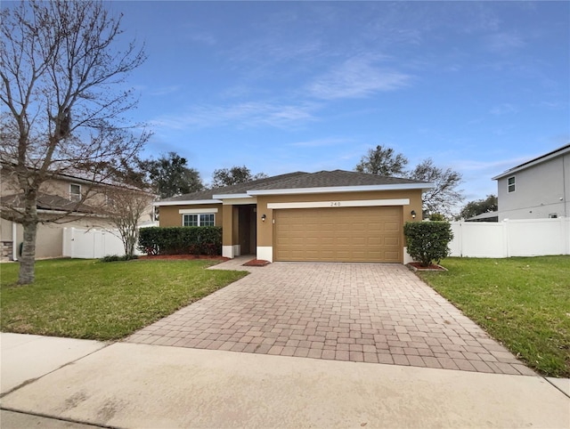 view of front of house featuring a garage, decorative driveway, a front lawn, and stucco siding