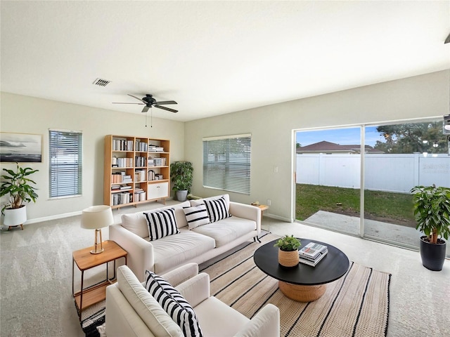 carpeted living area featuring baseboards, visible vents, and a ceiling fan