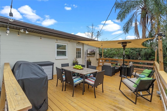 wooden terrace with an outdoor hangout area and grilling area