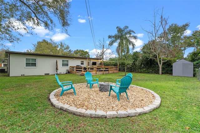 view of yard with an outdoor fire pit, a storage unit, and a wooden deck