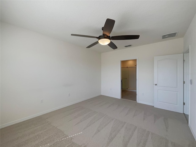unfurnished bedroom featuring light carpet, ceiling fan, visible vents, and baseboards
