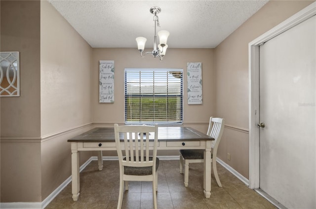 tiled dining room with baseboards, a chandelier, and a textured ceiling