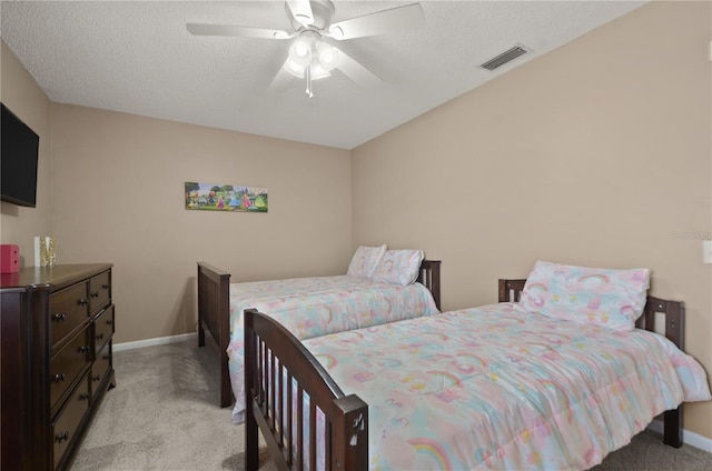 bedroom featuring light carpet, a textured ceiling, visible vents, and baseboards