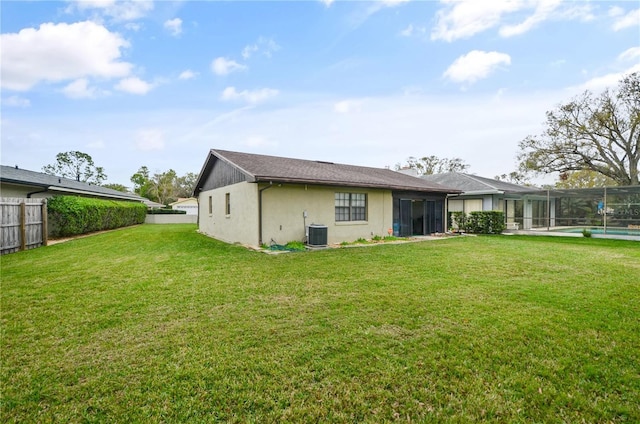 rear view of property featuring a fenced in pool, glass enclosure, a fenced backyard, cooling unit, and a yard