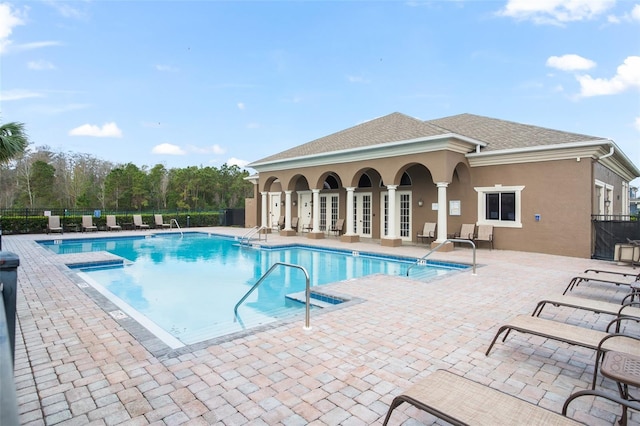 pool with a patio and fence