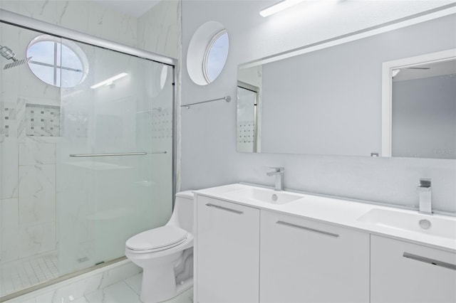 bathroom with marble finish floor, a stall shower, a sink, and toilet