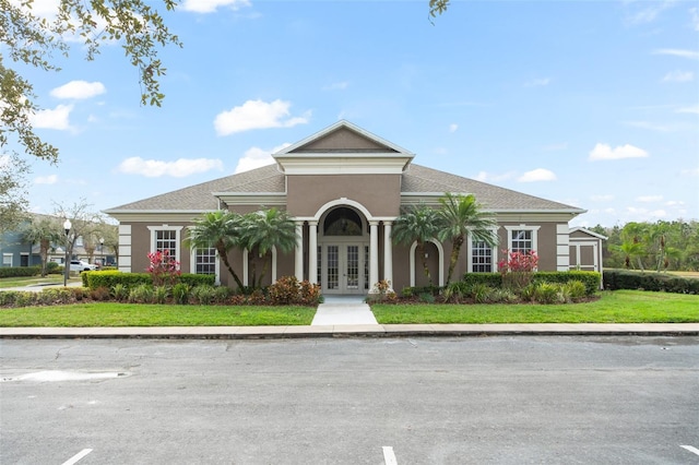 view of front of home with french doors, a front yard, and stucco siding