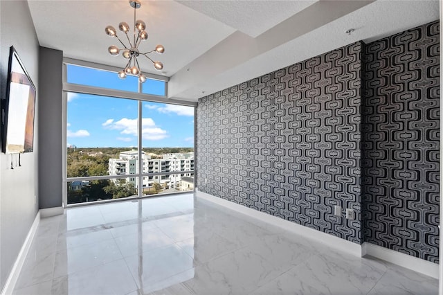 101 S Eola Dr Unit 1001, Orlando, FL 32801 - unfurnished room featuring marble finish floor, a textured ceiling, an inviting chandelier, a wall of windows, and baseboards