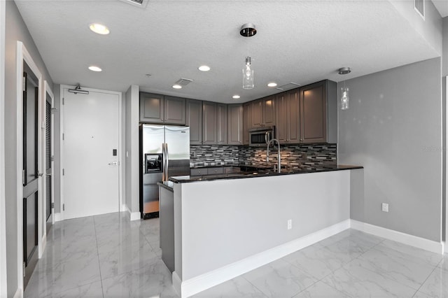 101 S Eola Dr Unit 1001, Orlando, FL 32801 - kitchen featuring dark countertops, backsplash, appliances with stainless steel finishes, a peninsula, and marble finish floor