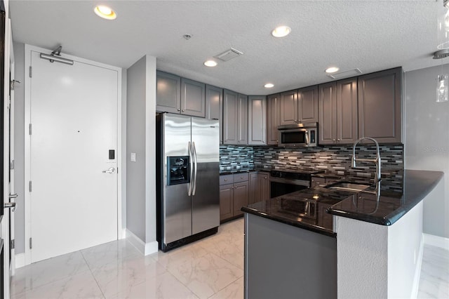101 S Eola Dr Unit 1001, Orlando, FL 32801 - kitchen with a peninsula, a sink, stainless steel appliances, marble finish floor, and backsplash