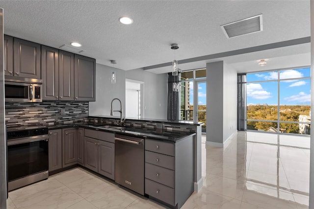 101 S Eola Dr Unit 1001, Orlando, FL 32801 - kitchen featuring visible vents, marble finish floor, a sink, stainless steel appliances, and a peninsula