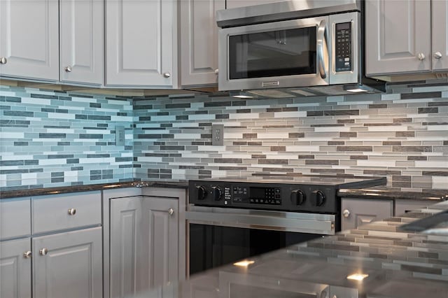 101 S Eola Dr Unit 1001, Orlando, FL 32801 - kitchen featuring stainless steel microwave, backsplash, white cabinets, and electric range