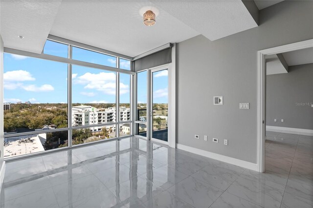 101 S Eola Dr Unit 1001, Orlando, FL 32801 - unfurnished room featuring expansive windows, baseboards, and marble finish floor