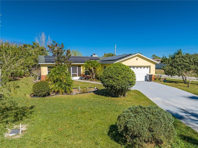 ranch-style house featuring a garage, solar panels, and a front lawn