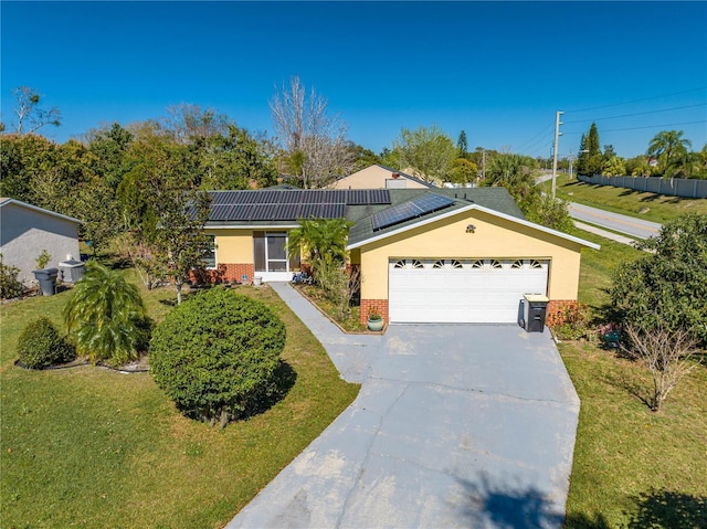 ranch-style home with a front lawn, solar panels, and a garage