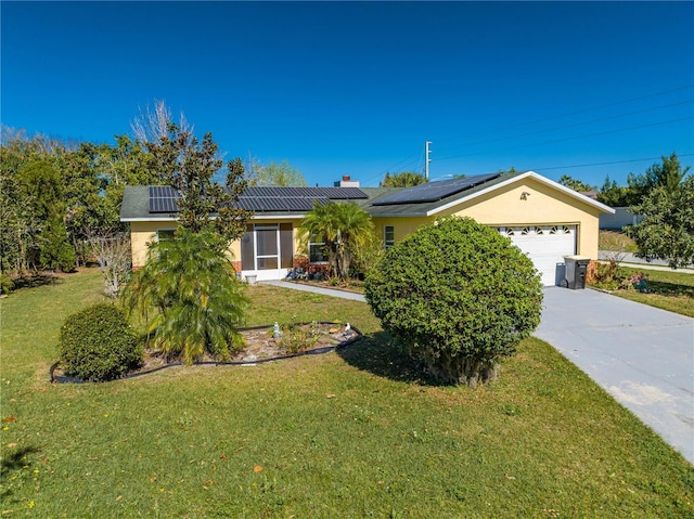 single story home featuring a garage, solar panels, and a front lawn