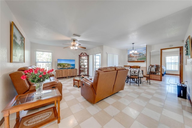 living room with ceiling fan with notable chandelier